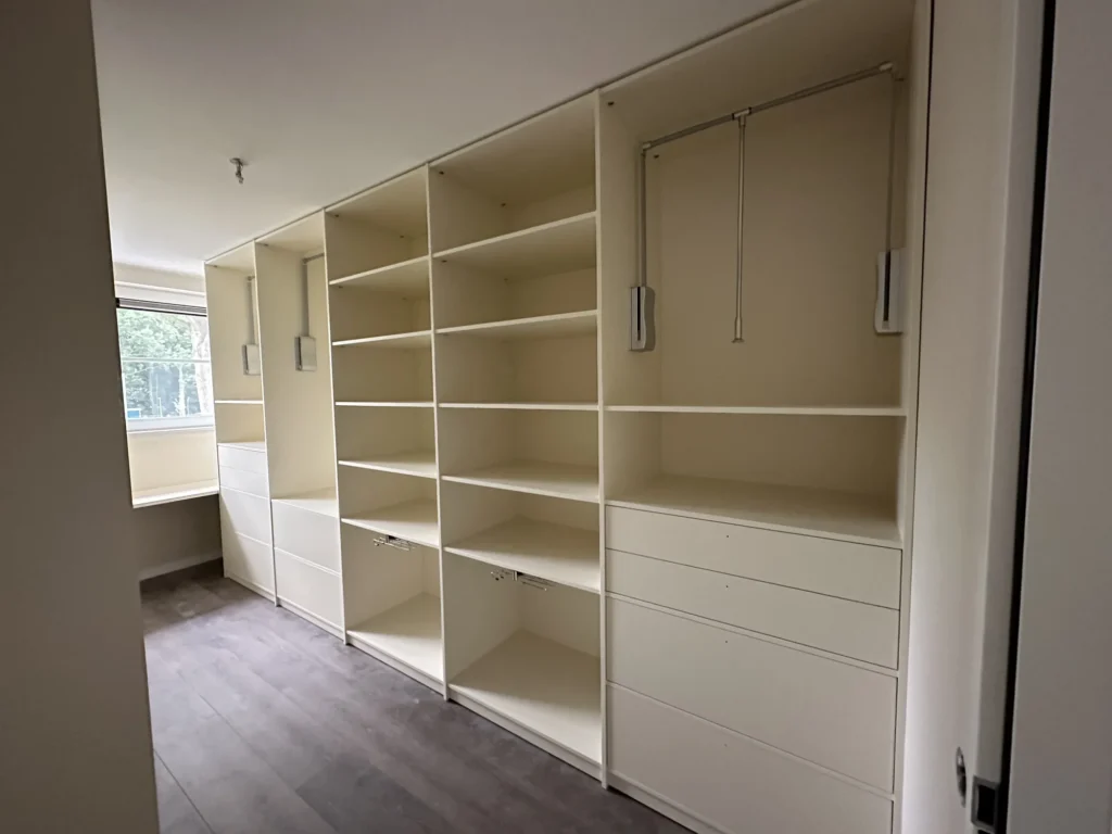 Witte open inloopkast op maat met kledingroedes, legplanken en brede lades