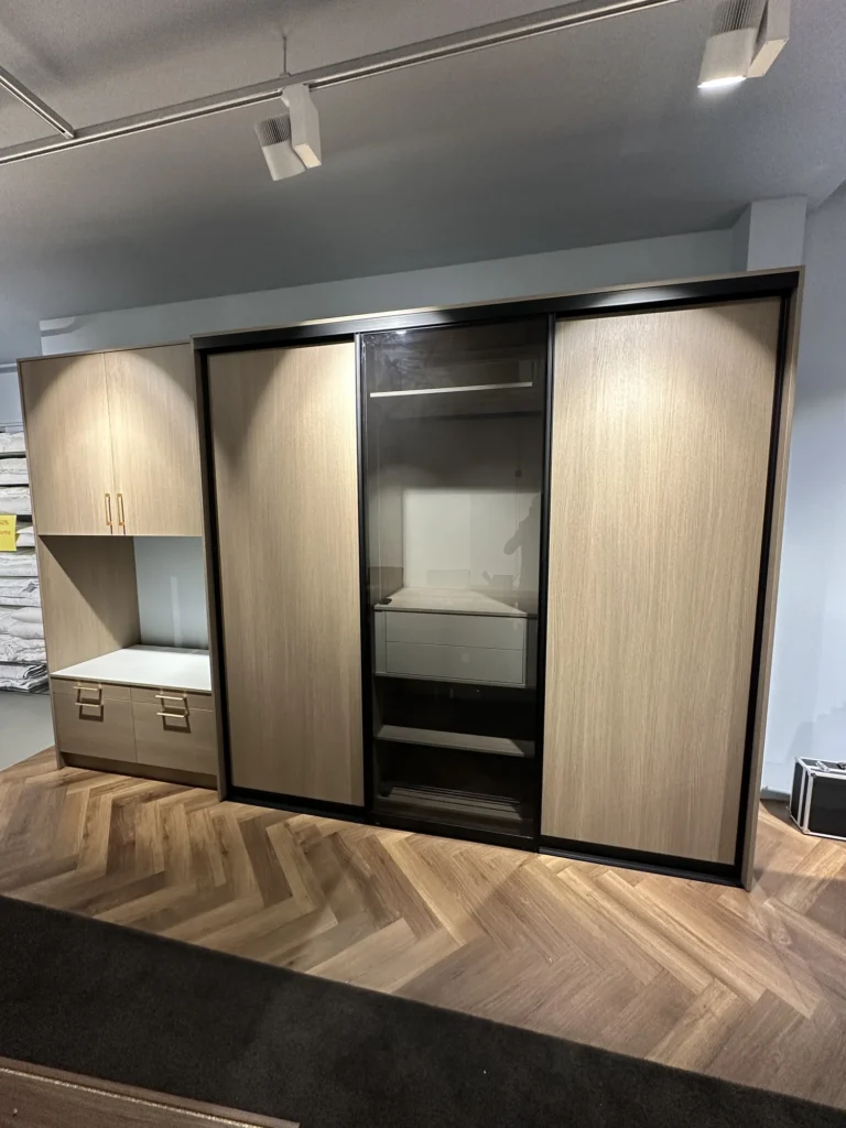 Kast met schuifdeuren in warm houtdecor met zwarte profielen