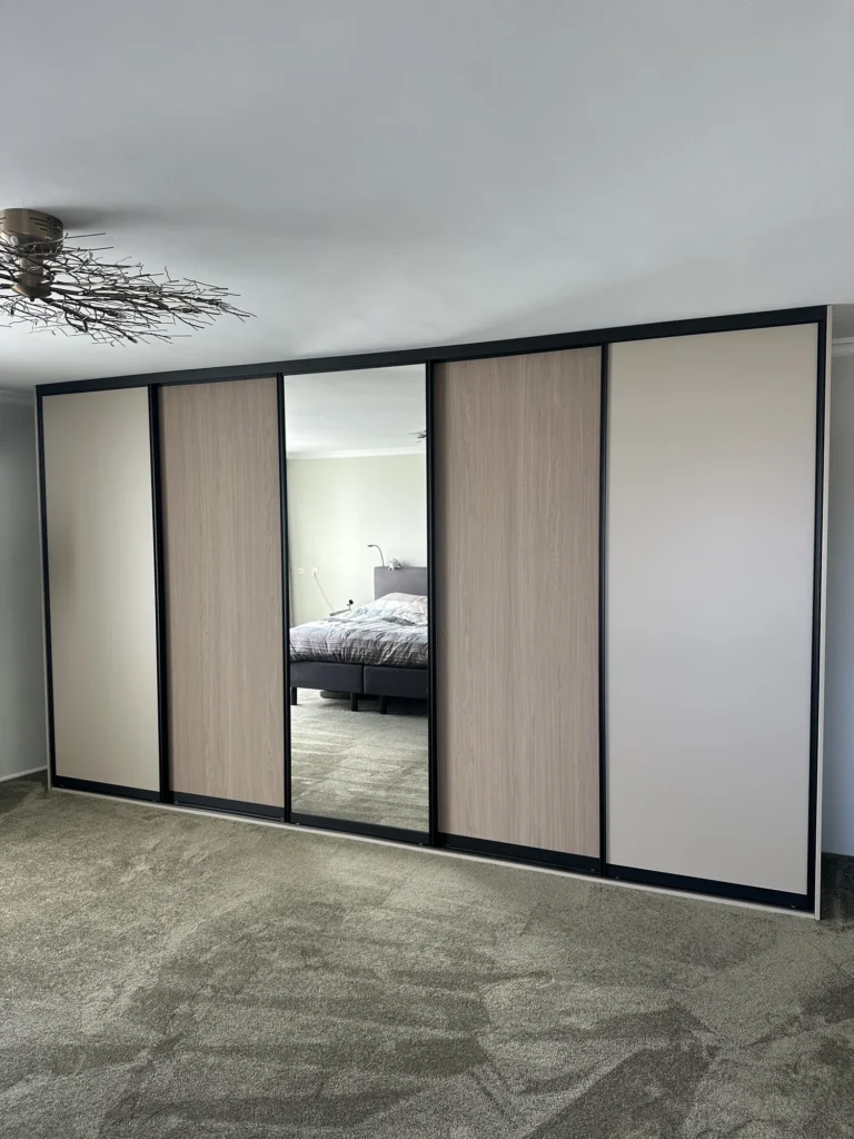 Kast met schuifdeuren in wit, spiegelglas en warm houtdecor