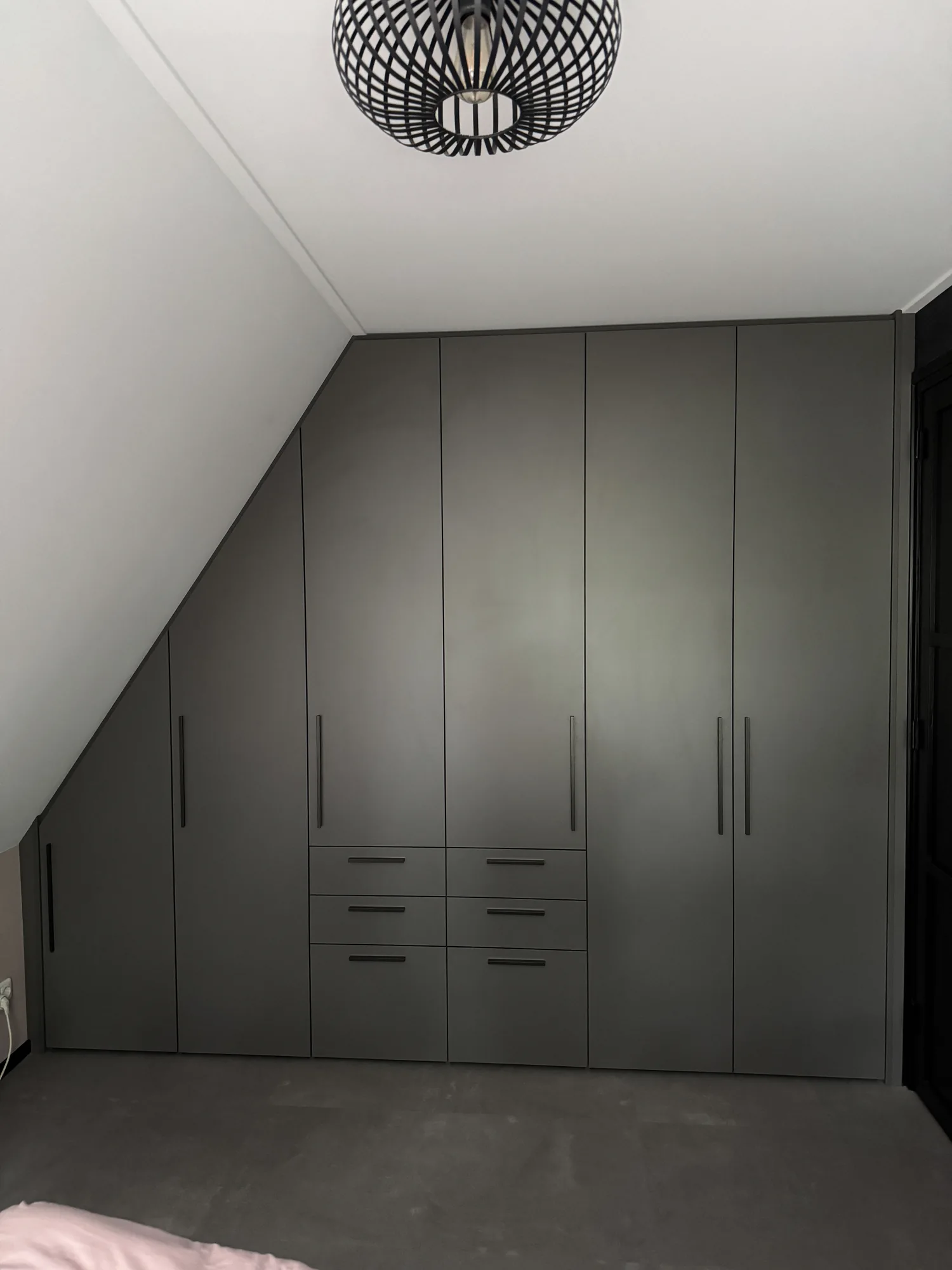 Antraciete kast op maat die aansluit op een schuine wand