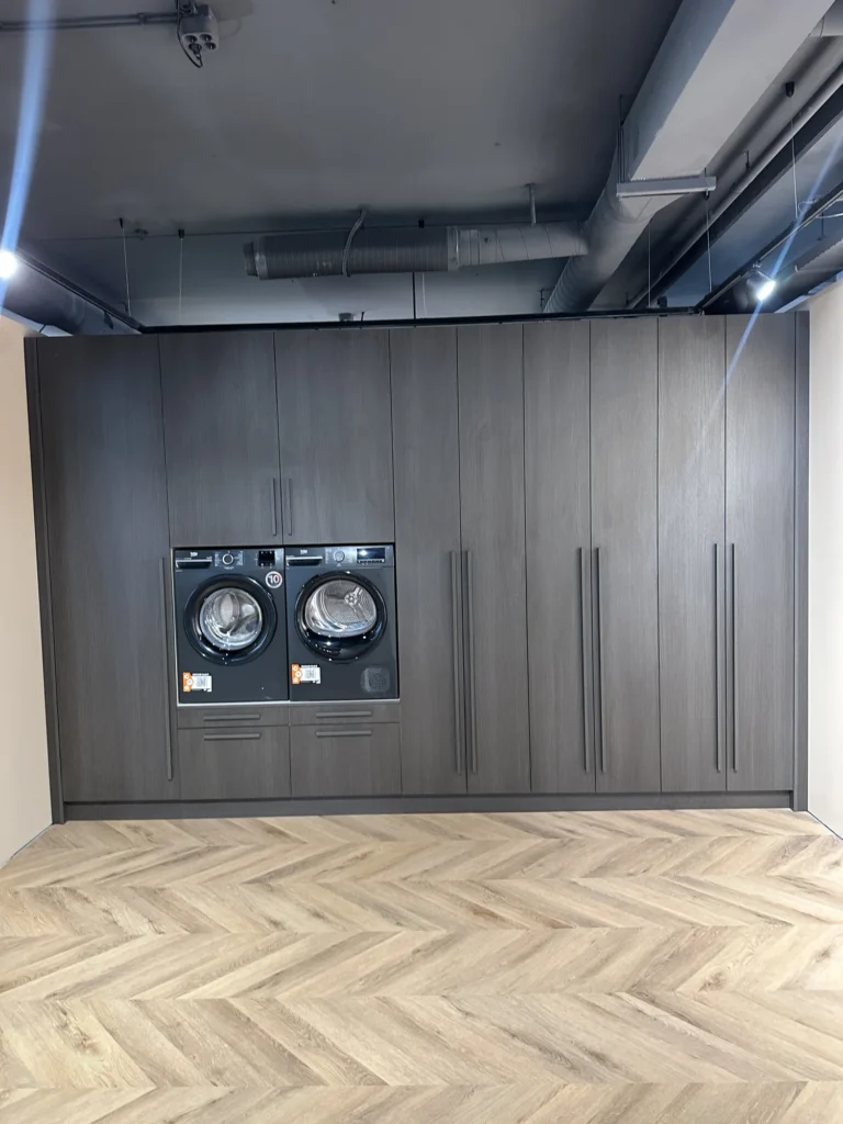 Donkere wasmachinekast op maat in houtdecor met apparatuur en gesloten bergruimte